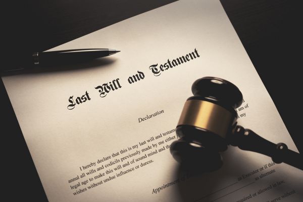A Last Will and Testament document on a desk, shown with a judge’s gavel and a pen.