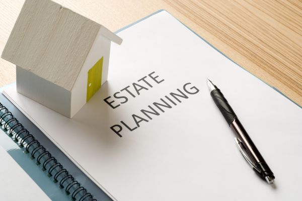 tiny-house-model-and-a-estate-planning-paper-with-pen