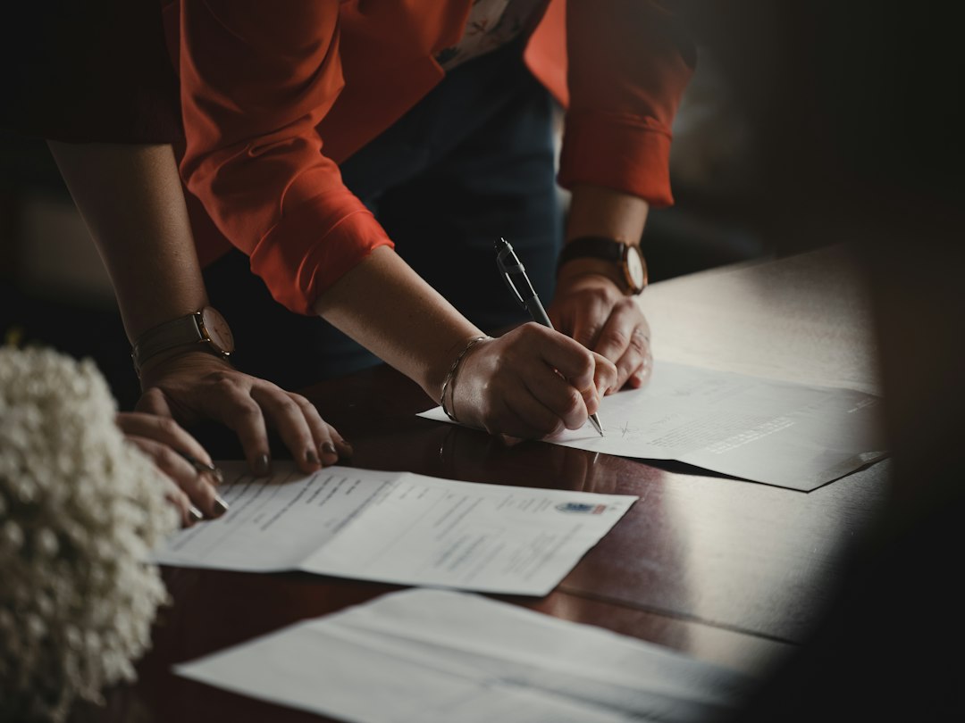 Older adult signing a durable power of attorney document with an agent present